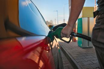 hand pumping diesel into red car side view
